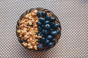 Bowl of whole grain muesli with blueberries on a table background