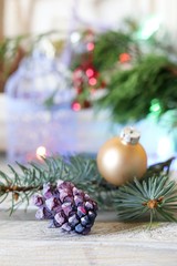  On a wooden table Christmas ball, cones, spruce branches, decorative lights, illumination, decorate the interior for seasonal winter holidays