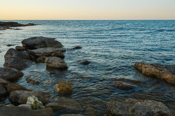 Evening on the background of the sea stone coast