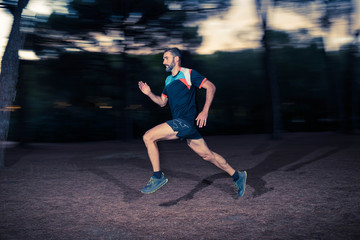 Middle aged caucasian man trail runner training fast speed in the forest