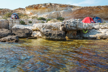 Camping on a rocky seashore. View from the water