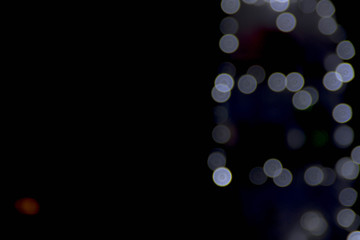 White highlights on a black abstract background of colored dust particles illuminated from the real flash colorful bokeh