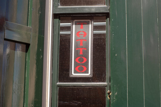 Tattoo Sign On The Green Wall Of A Tattoo Shop