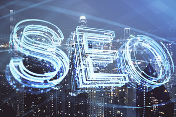 SEO hologram on city view with skyscrapers background double exposure. Search optimization concept.