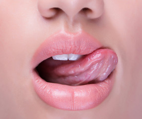 Anonymous shot of an open mouth with tongue licking juicy lips. - obrazy, fototapety, plakaty