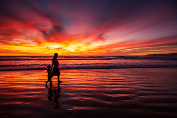 mother and son having fun at sunset on the beach