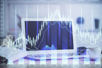 Stock market graph on background with desk and personal computer. Double exposure. Concept of financial analysis.
