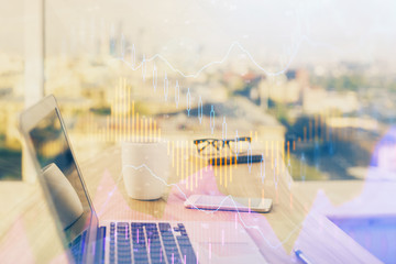Stock market graph on background with desk and personal computer. Double exposure. Concept of financial analysis.
