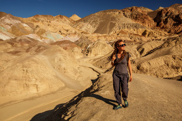 Fototapeta premium A hiker in the Artist`s Palette landmark place in Death Valley National Park, Geology, sand.