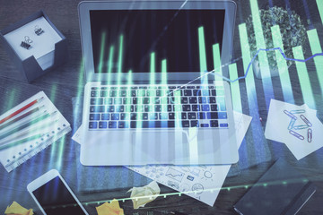 Financial chart drawing and table with computer on background. Double exposure. Concept of international markets.