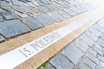 15th meridian line in cobbled street of Jindrichuv Hradec, Czech Republic. Inscription 15. polednik means 15th meridian