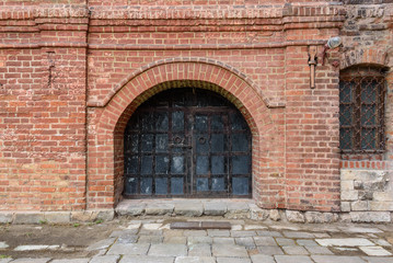 Fototapeta na wymiar Antique iron gates in the old brick wall