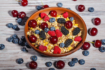 Clay bowl with muesli and fresh berries