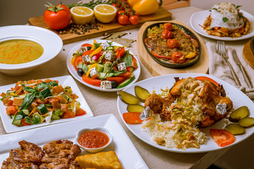 assorted food set on table. Turkish cuisine. lula kebab in Turkish on the board, greek salad, stew, fried eggplant, and fried chicken
