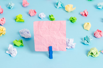 Colored crumpled papers empty reminder blue floor background clothespin