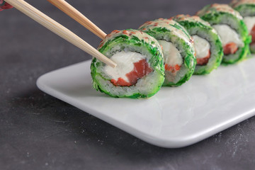 Eating Sushi with chopsticks.Closeup Sushi roll japanese food in restaurant