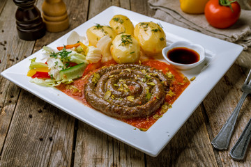 fried snail sausages with tomato sause and potatoes on the Board