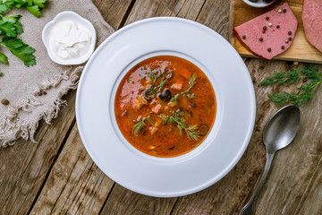 Meat Solyanka soup on wooden table