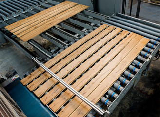 Production line of the wooden floor factory. CNC automatic woodworking machine.