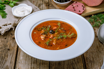 Meat Solyanka soup on wooden table