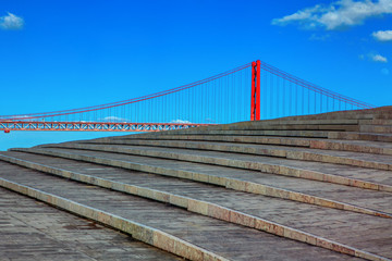 view of stone stairs and famous bridge in Lisbon