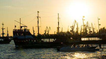 Fototapeta premium ship in the harbor, ships at sunset. cranes in the port