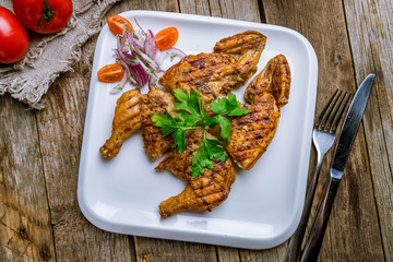 fried chicken tobacco on white plate on wooden table