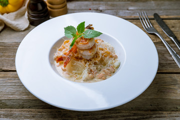 Fettuccine with shrimp on old wooden table