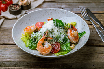salad caesar with shrimps on old wooden table