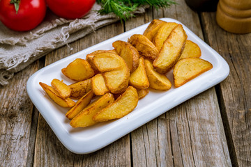 The potatoes wedges on wooden table