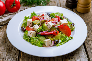 Greek salad with feta on wooden table