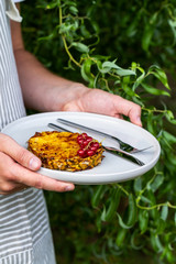 Grilled pineapple slice served with red currant on plate. Man, holding a plate with grilled ananas in the garden. Summer barbecue. Pineapple with cinnamon and salt.