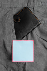 Small little wallet inside man trousers front pocket near notation paper