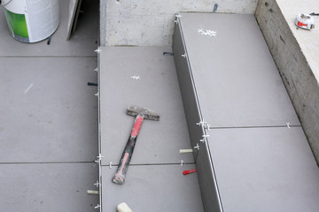 Tiler hands working on a new house entrance, local and professional handyman applying tiles to the steps.