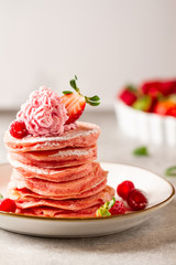 Stack of pink pancakes with strawberry. Pink colourful pancakes with berries. Breakfast