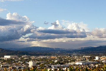 panaramic view of city businesses and homes with hillside homes and mountains