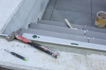 Tiler hands working on a new house entrance, local and professional handyman applying tiles to the steps.