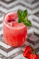 Fresh strawberry cocktail. Fresh summer cocktail with strawberry and ice cubes. Stawberry lemonade with leaves of mint.
