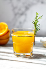Glass of freshly pressed orange juice with orange squeezed halves on the table