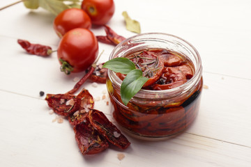 Glass jar with sun dried tomatoes on wooden table