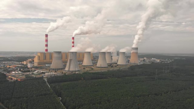 Aerial view of Belchatow coal power plant. Biggest fossil fuel emission producer in Europe increasing climate change. Smoke rising from chimneys and water vapor from cooling towers. Poland