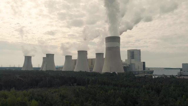 Aerial view of Belchatow coal power plant. Biggest fossil fuel emission producer in Europe increasing climate change. Smoke rising from chimneys and water vapor from cooling towers. Poland