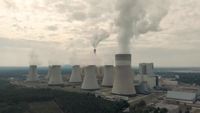 Aerial view of Belchatow coal power plant. Biggest fossil fuel emission producer in Europe increasing climate change. Smoke rising from chimneys and water vapor from cooling towers. Poland