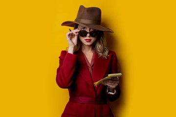 Woman in sunglasses with notebook and pen