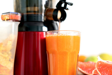 Preparing juice from fresh fruits and vegetables. Electric juicer, healthy lifestyle concept