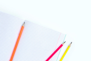 Fototapeta na wymiar Blank notebook and pencils on white background. School supplies. White sketch book with colourful pencils. Note book and pencil