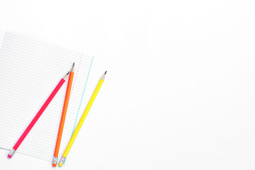 Blank notebook and pencils on white background. School supplies. White sketch book with colourful pencils. Note book and pencil