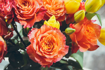Background of orange and yellow roses. Floral background. Orange, yellow, red roses close-up.