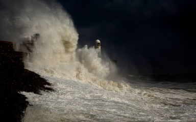Fototapeta na wymiar Porthcawl lighthouse and pier in the jaws of a storm on the coast of South Wales, UK.