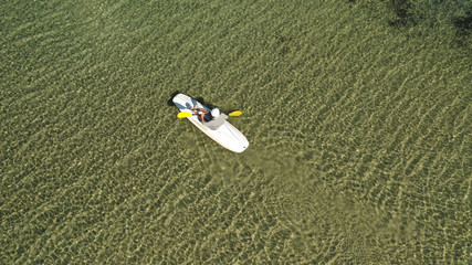Obraz premium Aerial drone photo of young man practising canoe in tropical bay with calm sea